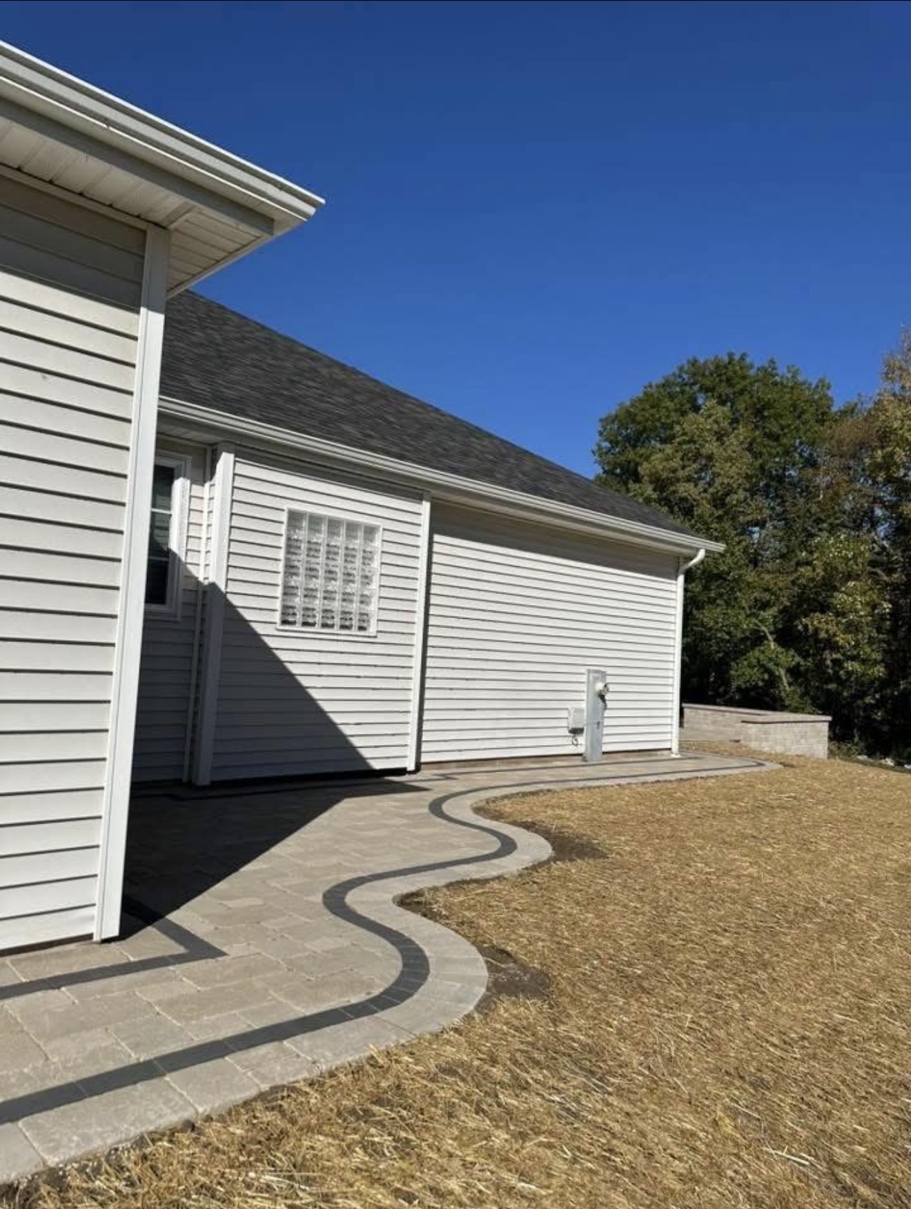 Curved paver walkway leading to home with contrasting border