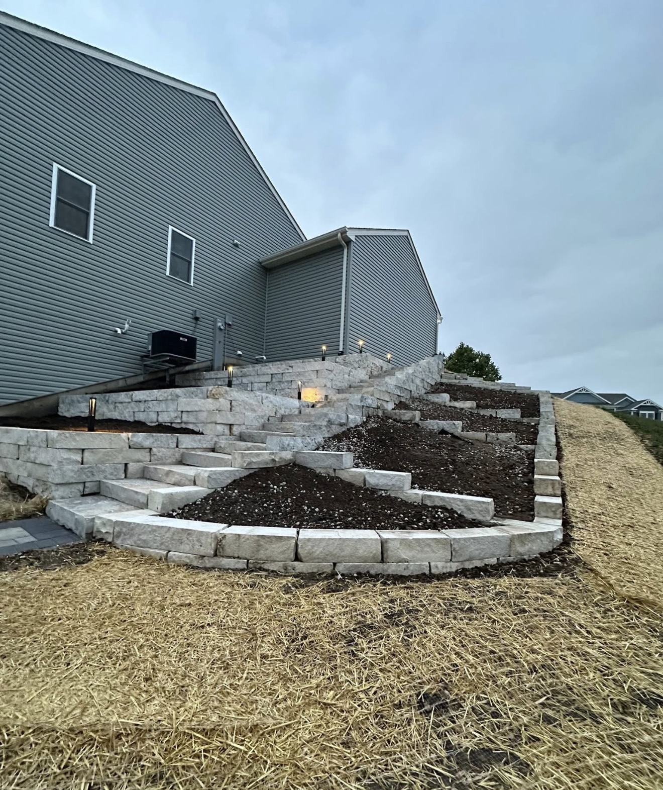 Tiered retaining wall with natural stone steps and lighting